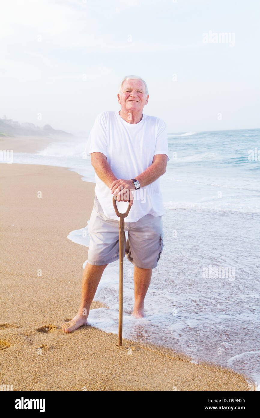 Elderly man walking alone on beach hires stock photography and images