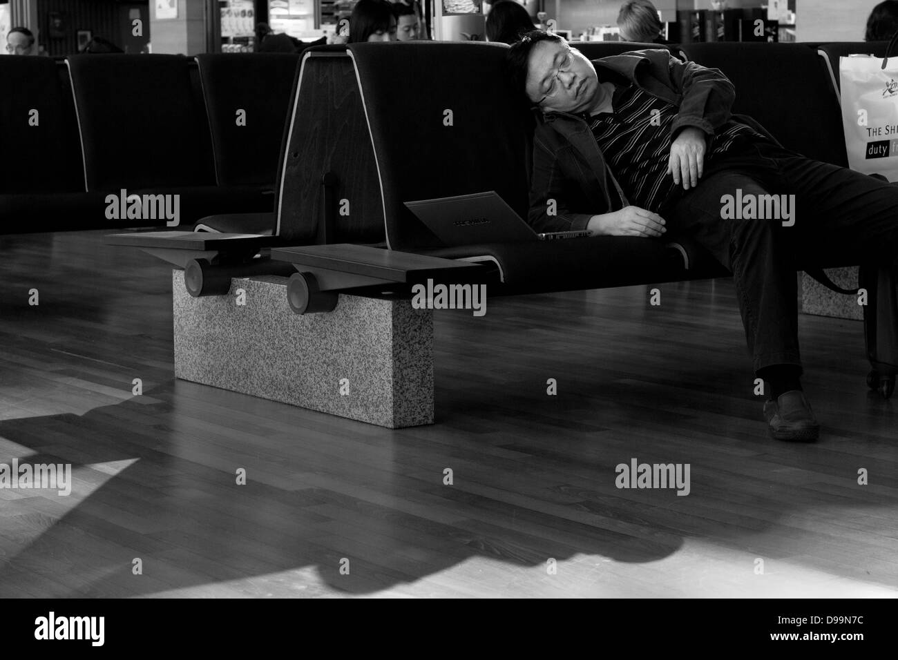 INCHEON AIRPORT, SOUTH KOREA NOVEMBER 22 2012: passenger dozes off in while waiting to board flight Stock Photo