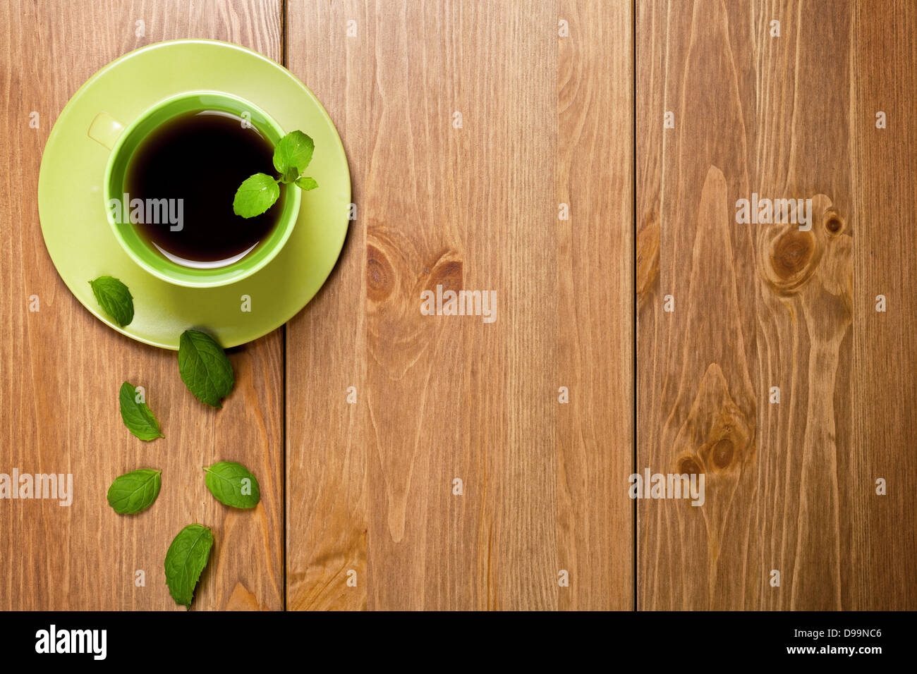 Tea mint in green cup with mint leaves on wooden table background. Top view Stock Photo
