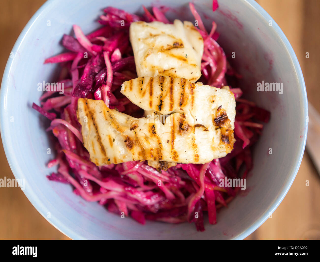 Raw cabbage, apple and beetroot slaw dressed in rice vinegar with grilled halloumi cheese Stock Photo
