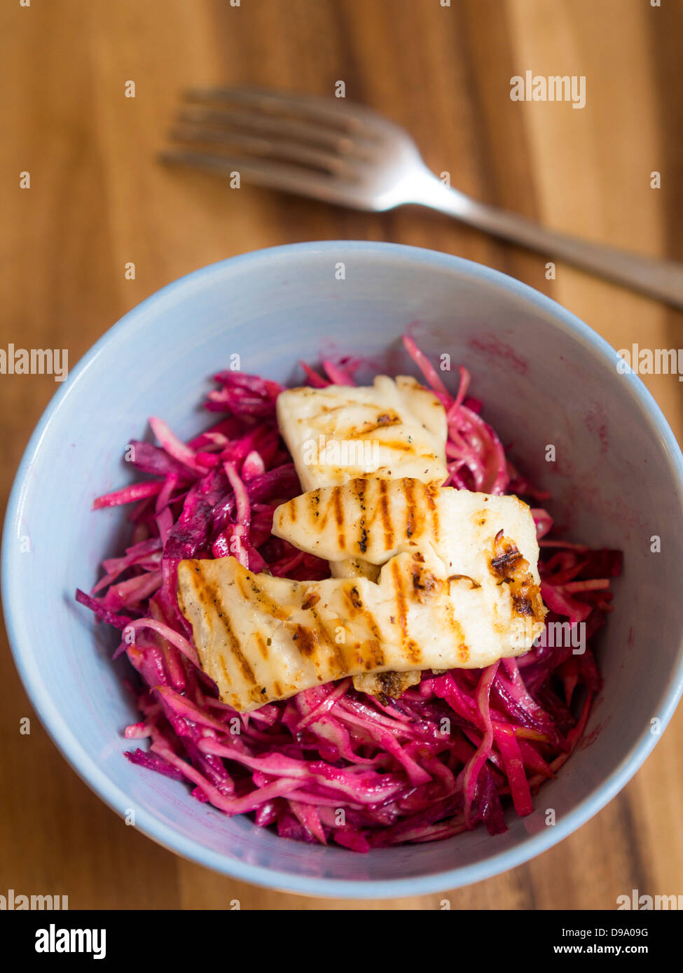 Raw cabbage, apple and beetroot slaw dressed in rice vinegar with grilled halloumi cheese Stock Photo