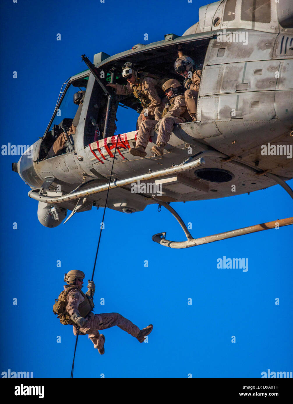 US Marine Corps Maritime Raid Force Marine members rappel from a UH-1N Huey during a helicopter rope suspension technique exercise at King Faisal Air Base June 11, 2013 in Jordan. Stock Photo