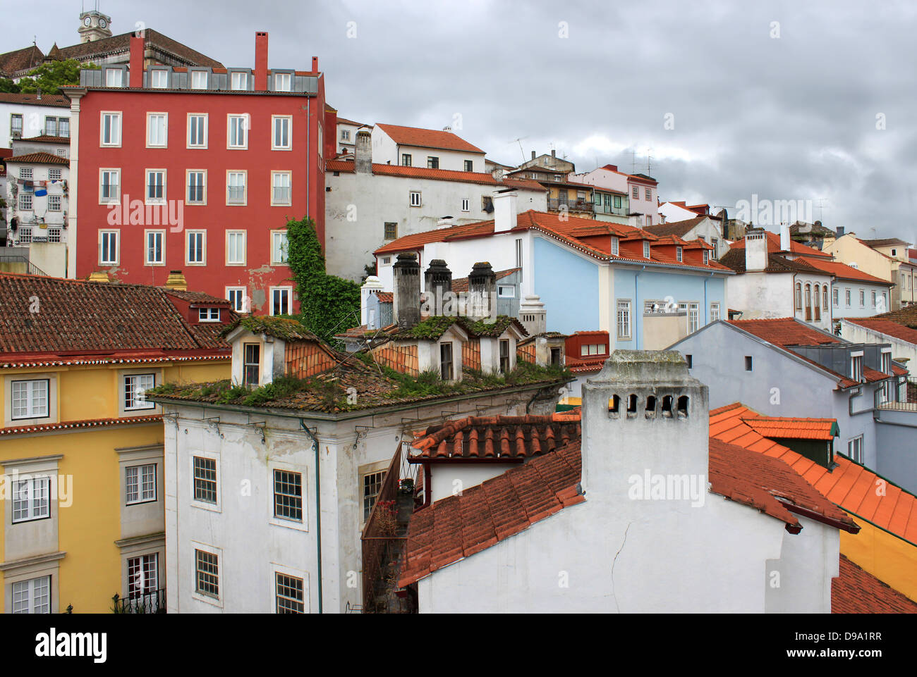 Colorful buildings and rooftops of Coimbra, Portugal under cloudy stormy skies Stock Photo