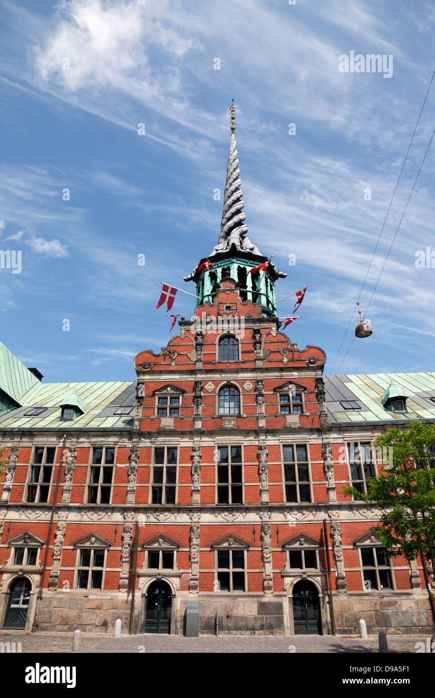 The old stock exchange, Børsen, flying the Danish flag from the turret openings to celebrate Valdemarsdag and Genforeningsdagen. Stock Photo