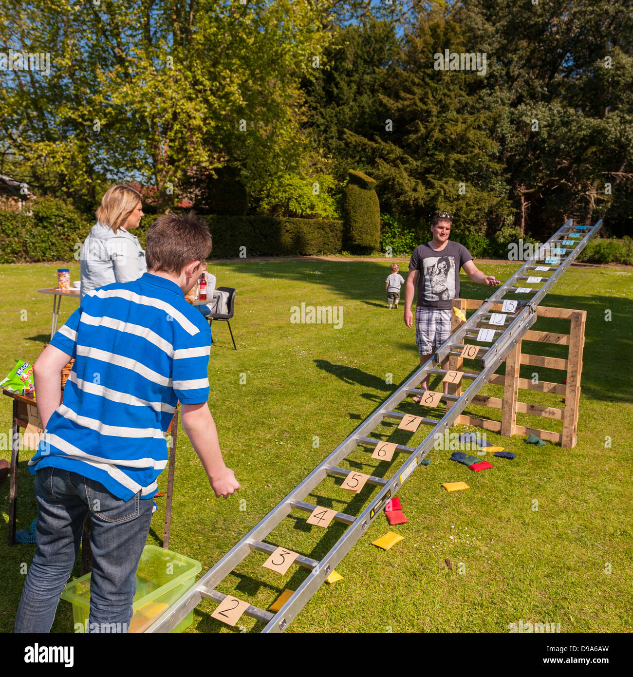 A Boy Playing The Ladder And Beanbag Game At A Village Fete At Stock a-boy-playing-the-ladder-and-beanbag-game-at-a-village-fete-at-stock