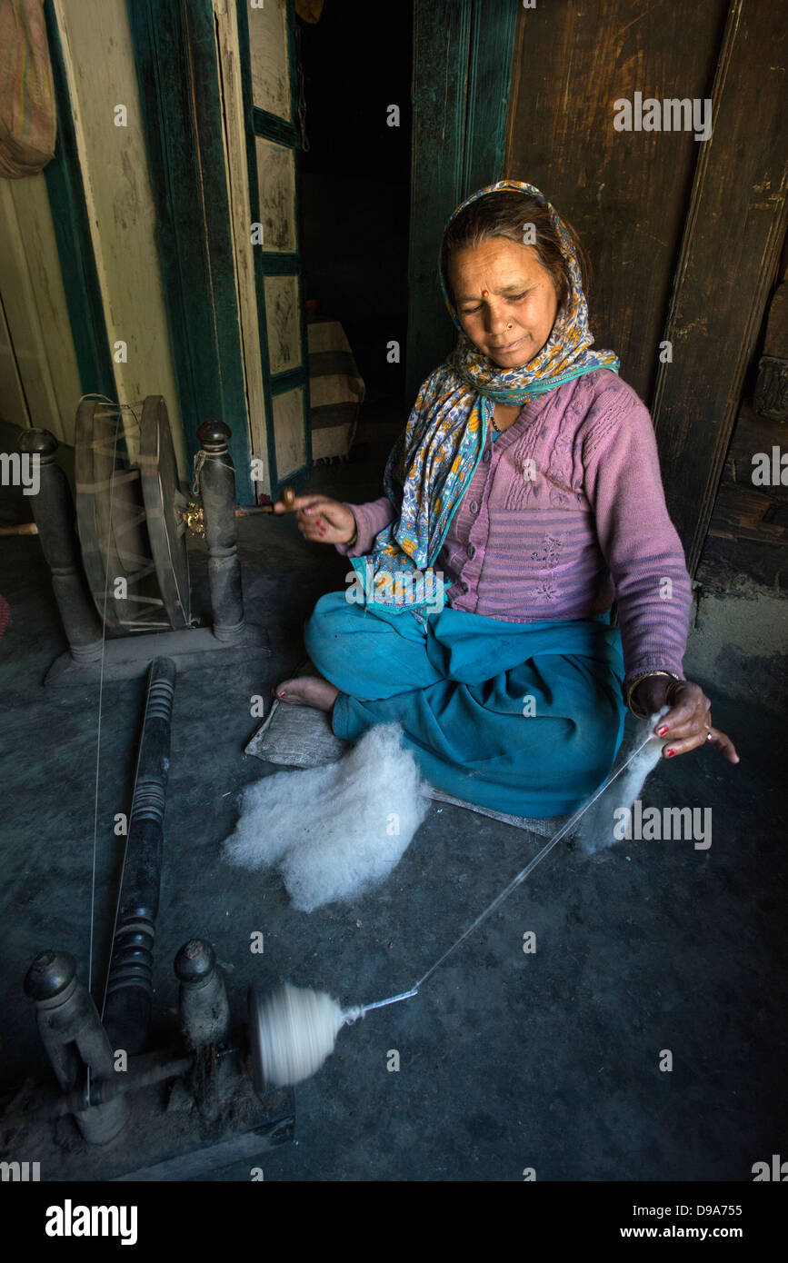 A Gaddi tribeswoman spins yarn from brushed wool in the Himalayan village of Kugti, Himachal Pradesh, India Stock Photo