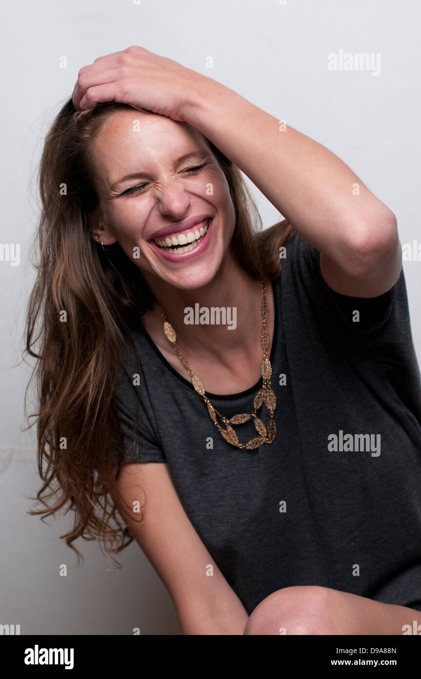 A laughing, hip and trendy young woman on white background Model release available Stock Photo