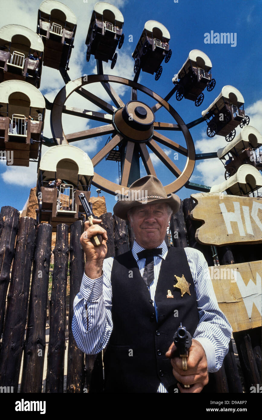 Cowboy sheriff costumed character in front of the High Sierra Wagon Wheel at The American Adventure Theme Park, Ilkeston, Derbyshire Stock Photo