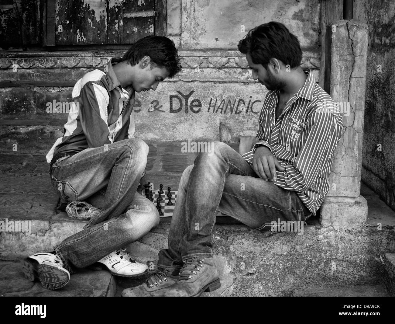 Two young men play chess on the street in Udaipur, Rajasthan, India Stock Photo