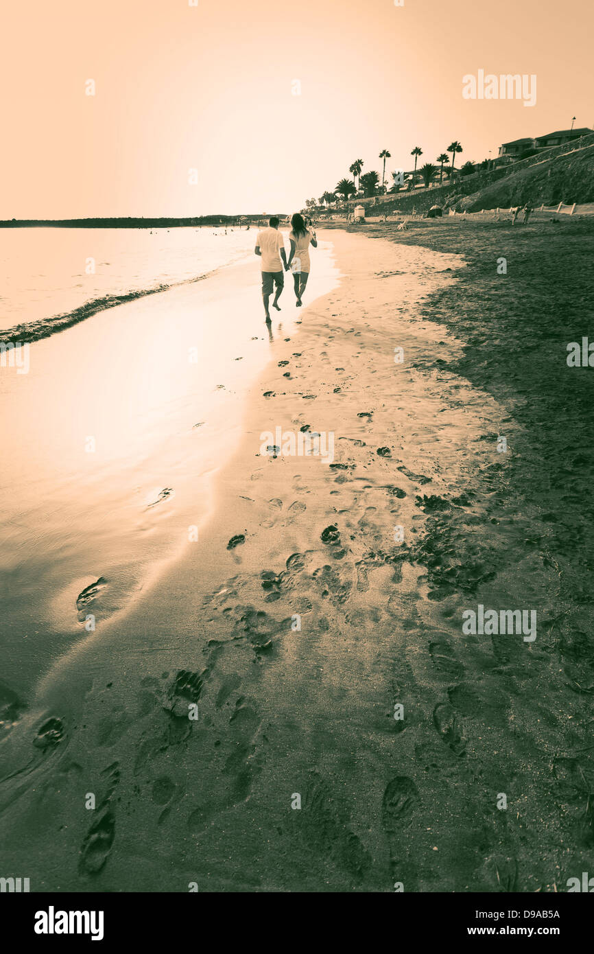 Couple run on beach hand in hand Stock Photo