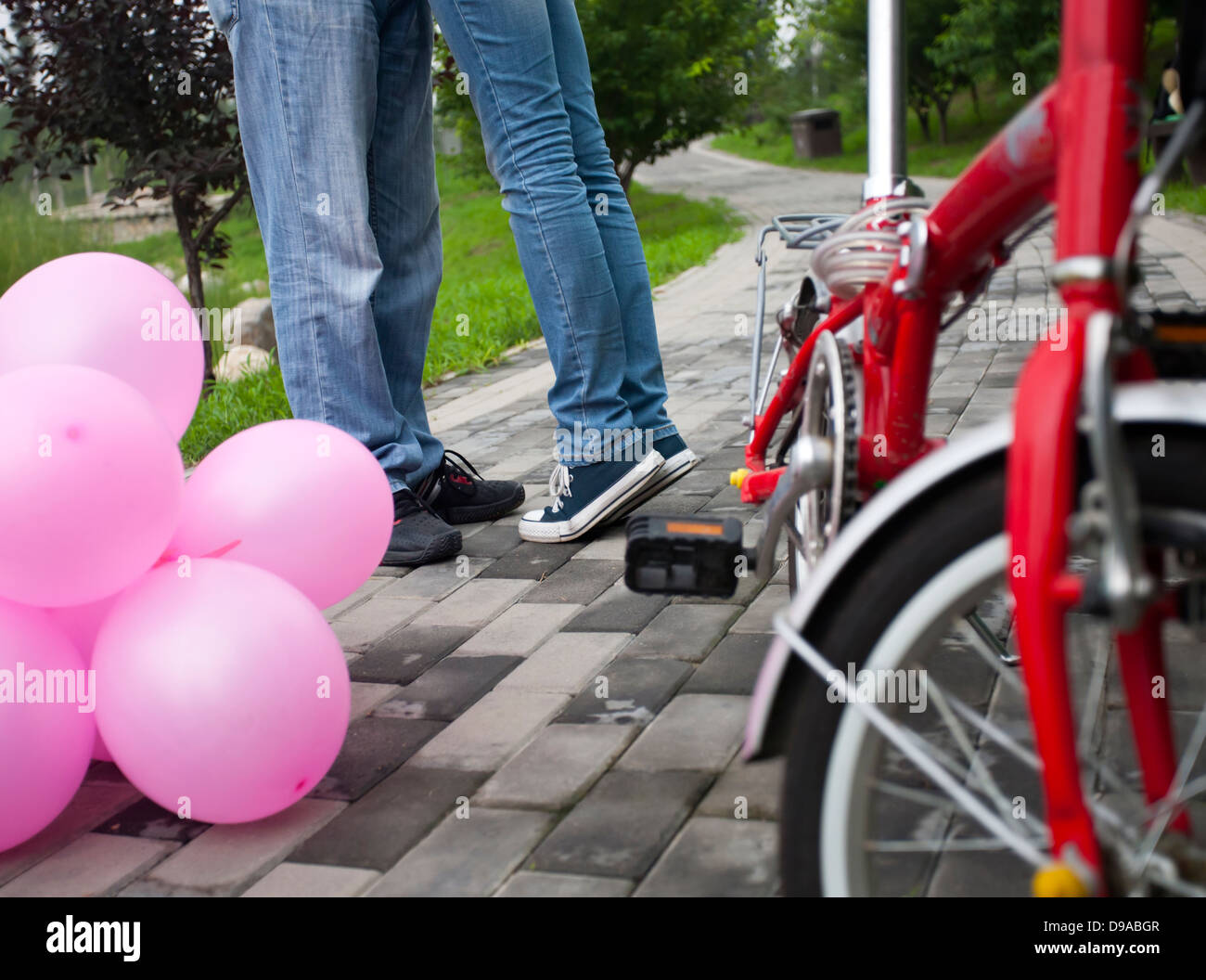 Romantic kissing with balloon and bike as foreground Stock Photo