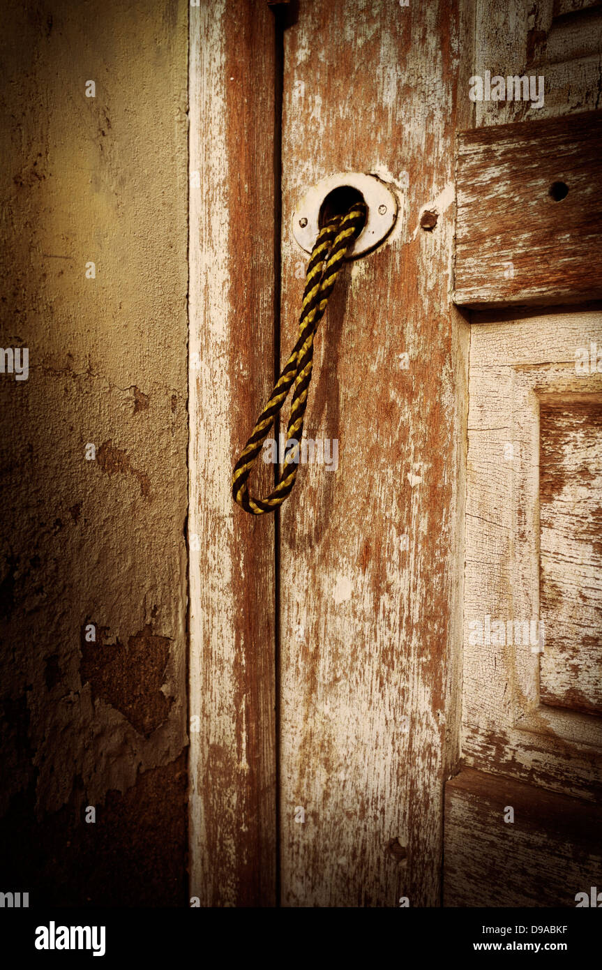 Old door neglected, faded paint with string pull handle Stock Photo - Alamy
