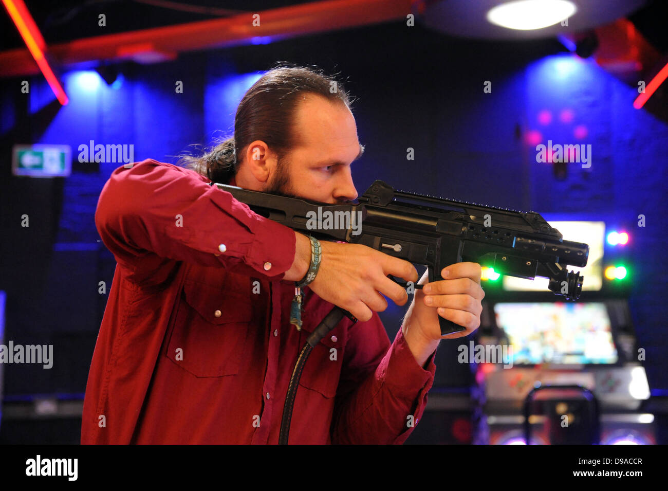 Man firing a gun in an arcade game at Namco funscape arcade, london. Stock Photo