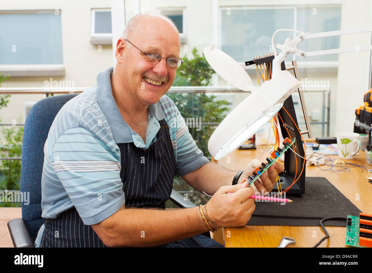 casual senior electrician at work Stock Photo