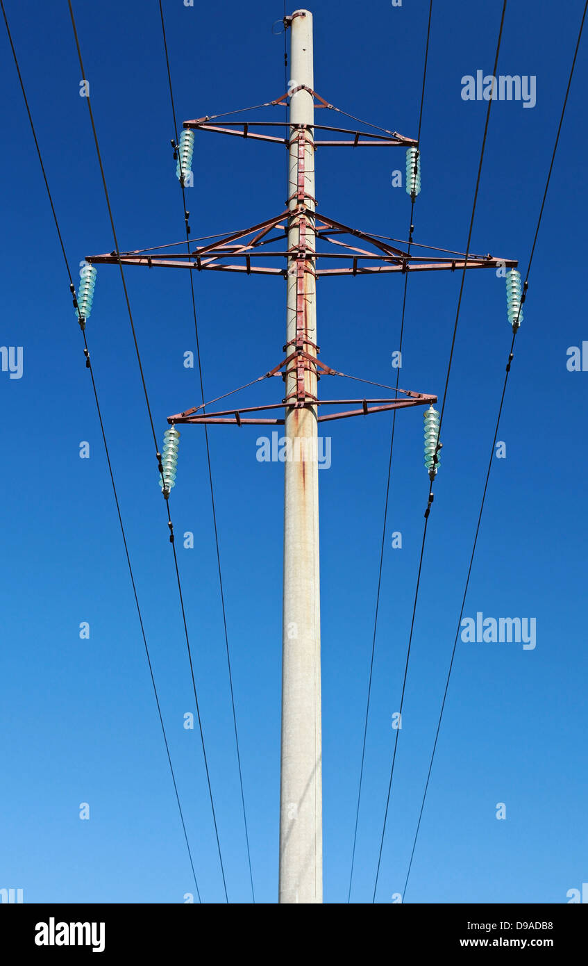 High voltage power lines and pylon above clear blue sky Stock Photo