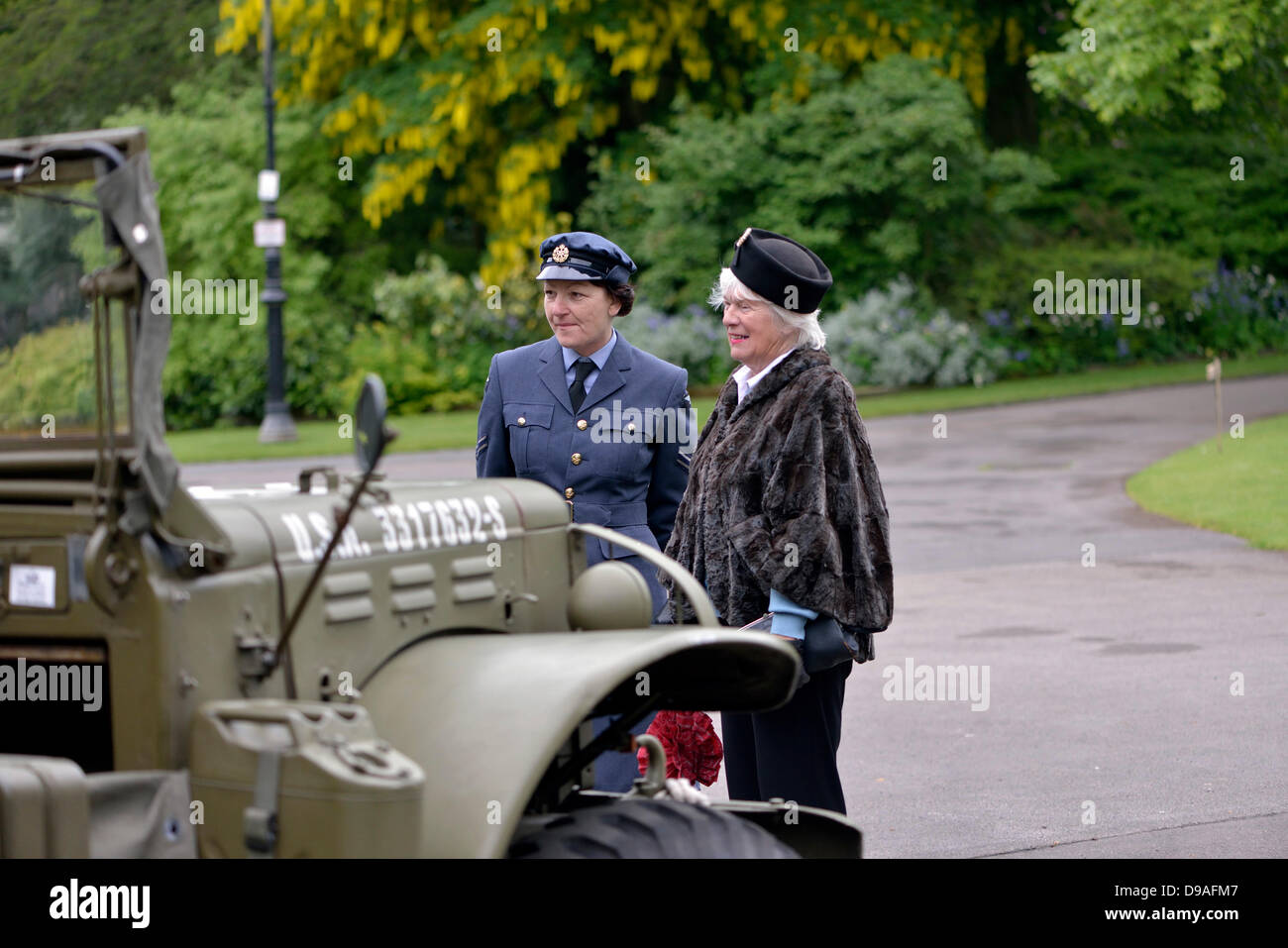 Harrogate, Yorkshire, UK. 16th June, 2013. A woman in a RAF uniform and a woman in 1940's dress admire a USA military vehicle at an event in Valley Gardens to raise money for The Magnesia Well Pump Room Project to create an exhibition on mineral springs. Credit:  John Fryer/Alamy Live News Stock Photo