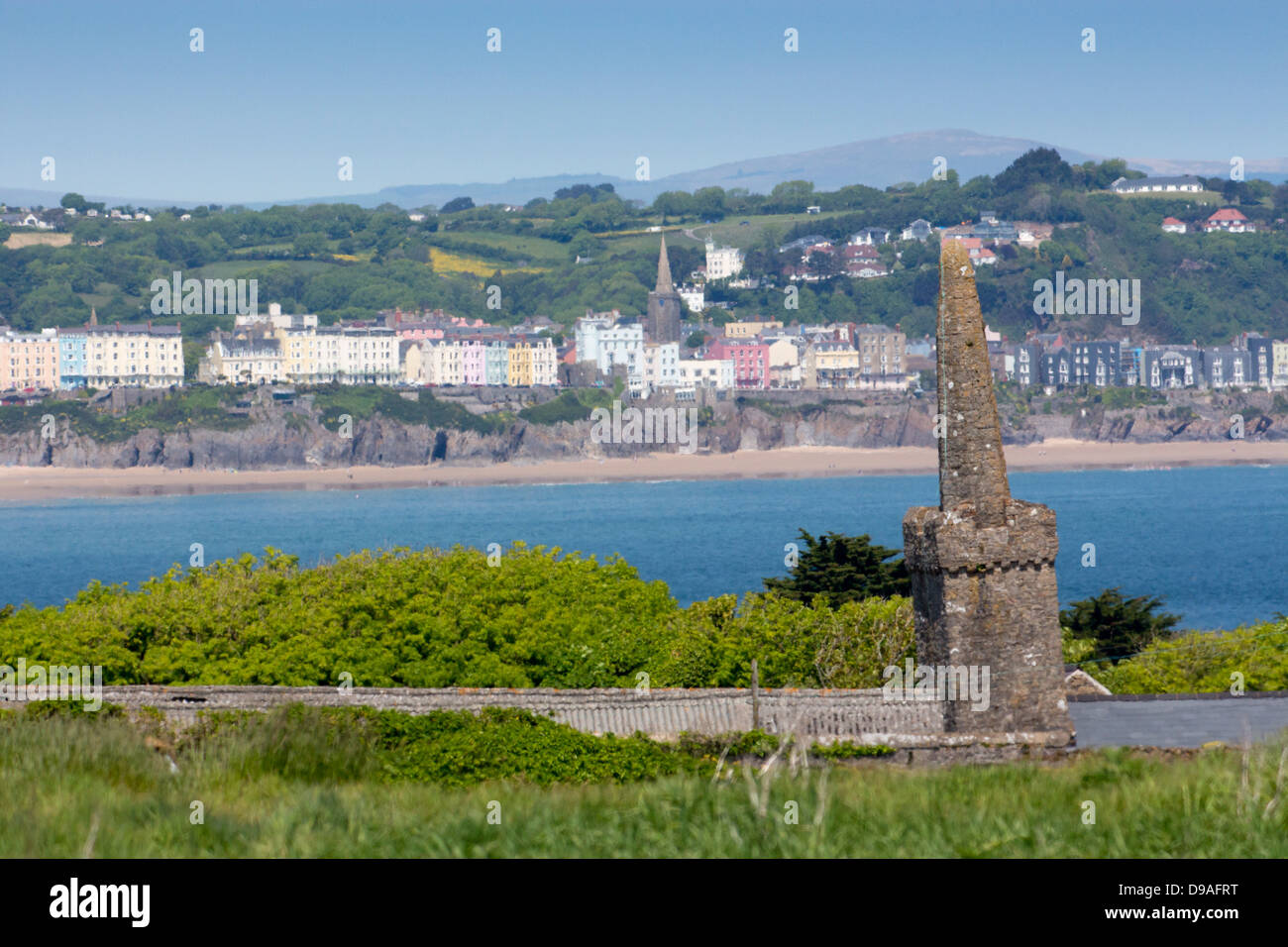The crooked spire of St Illtud's Church on Caldey Island with South Beach and Tenby town in background Pembrokeshire Wales UK Stock Photo