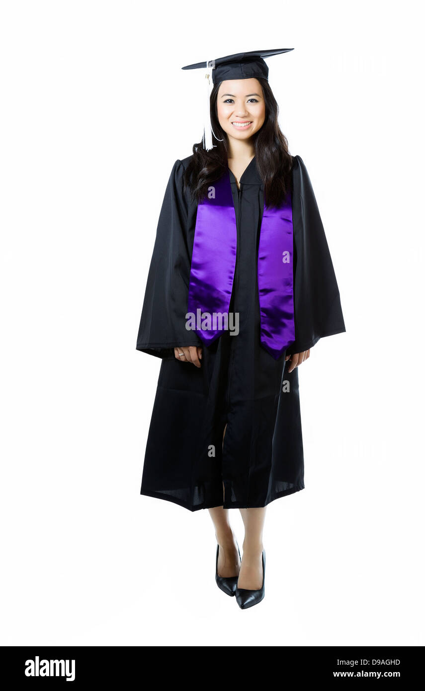 Vertical photo of young adult woman, dress in graduation gown and cap, on a white background Stock Photo