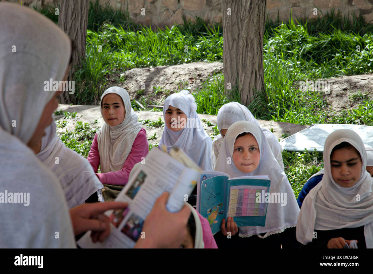 Afghan girls at the Naswan Shaher Kohna all-girls school read April 21, 2013 in Ghazni district, Afghanistan. Stock Photo