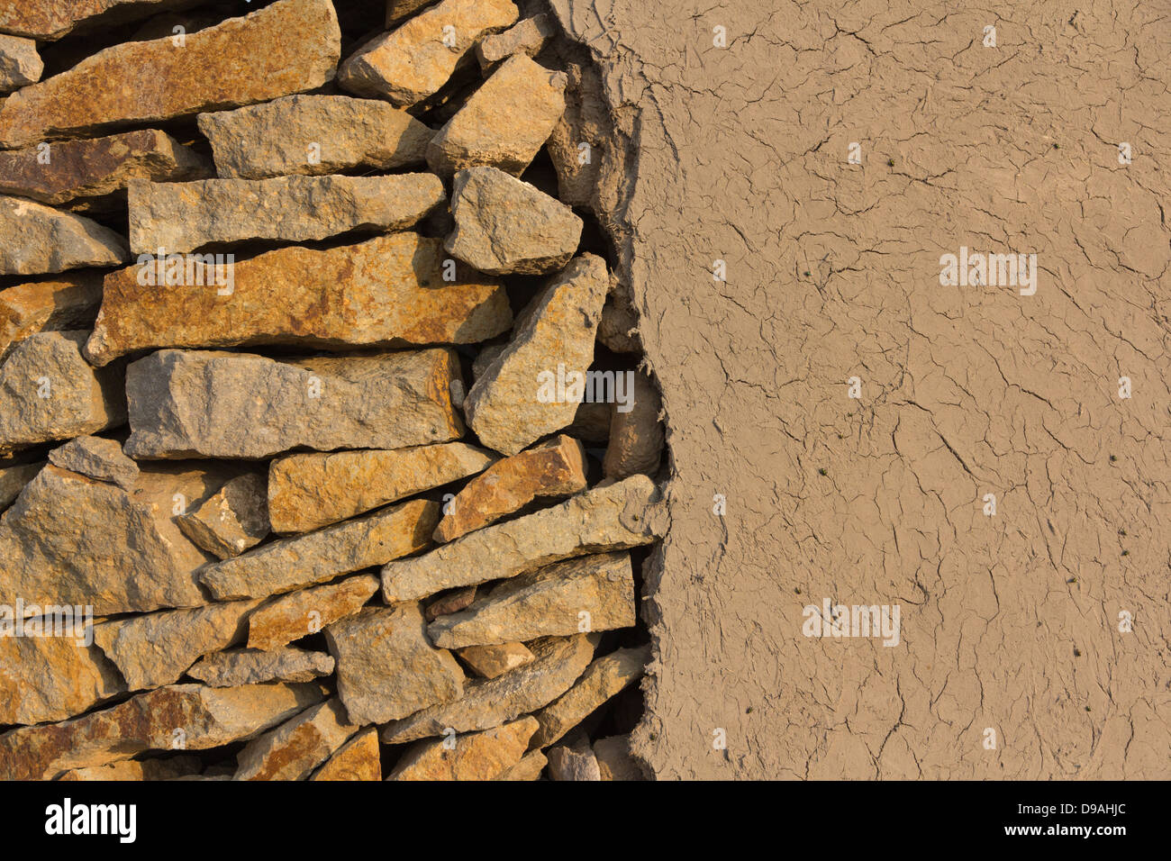 Wall of stones and loam in the evening sun Stock Photo