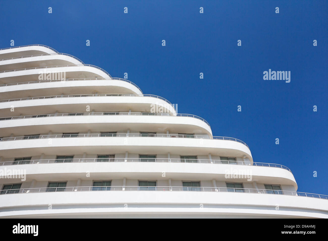 White building cascading down against blue sky Stock Photo
