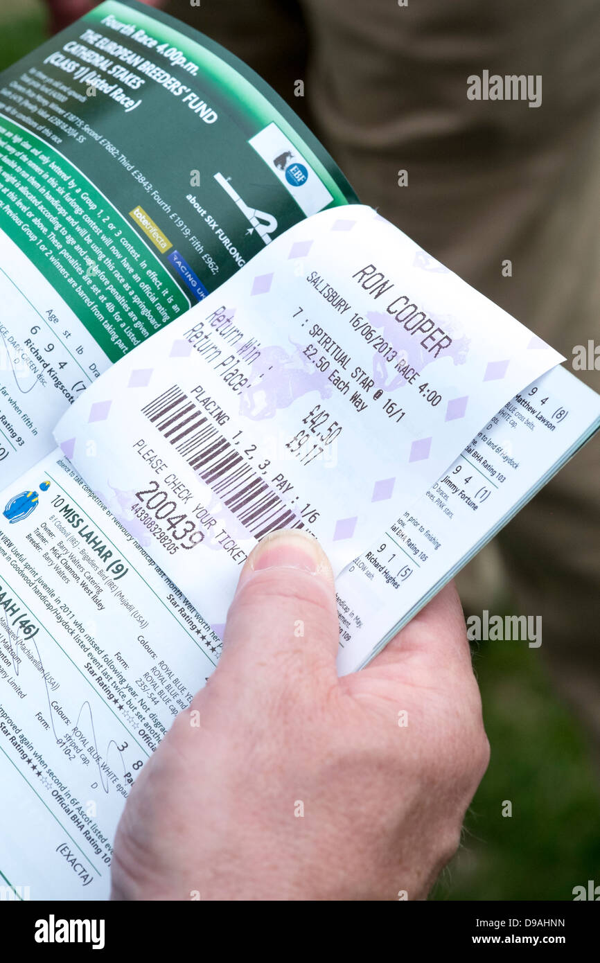 Hand holding horse racing betting slip and race programme Stock Photo