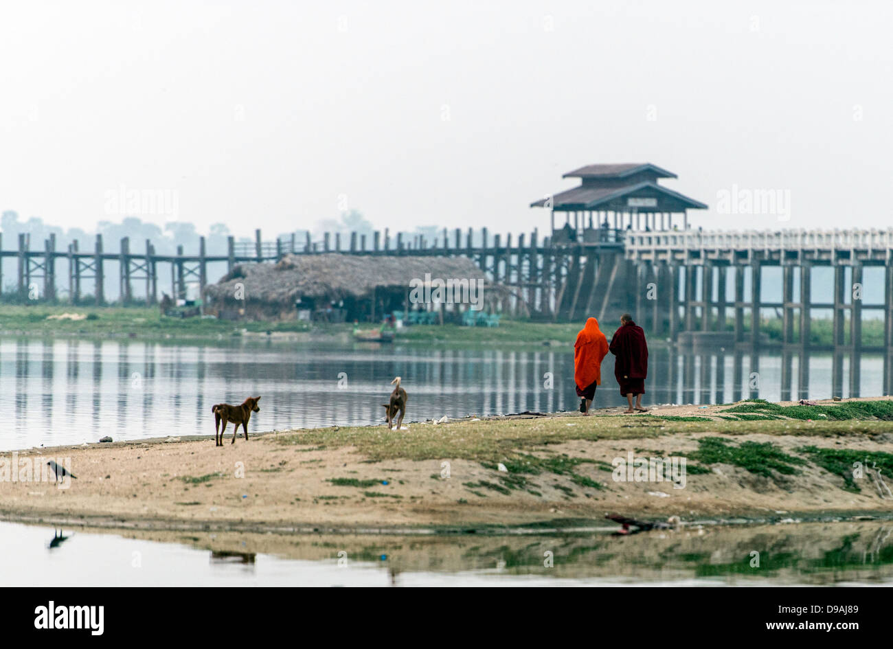 Two Buddhist monks walking by Ubein U Bein bridge Mandalay Burma Myanmar Stock Photo