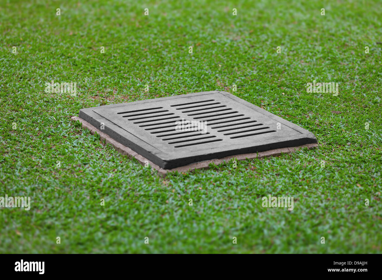 The sewer grate on the lawn - drainage for heavy rain Stock Photo