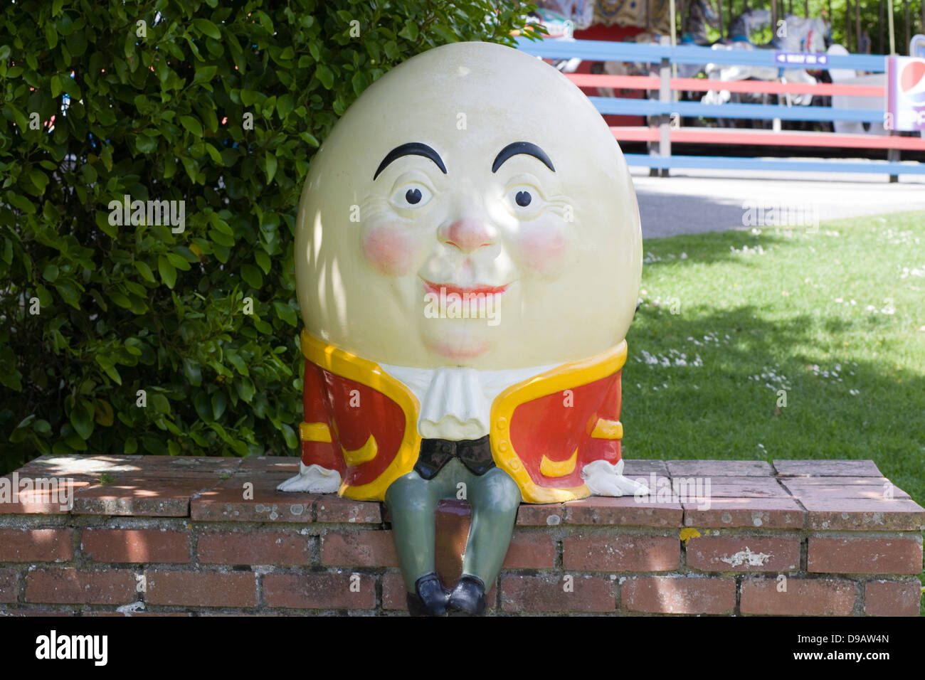 A Statue of Humpty Dumpty sat on a Red Brick Wall Stock Photo