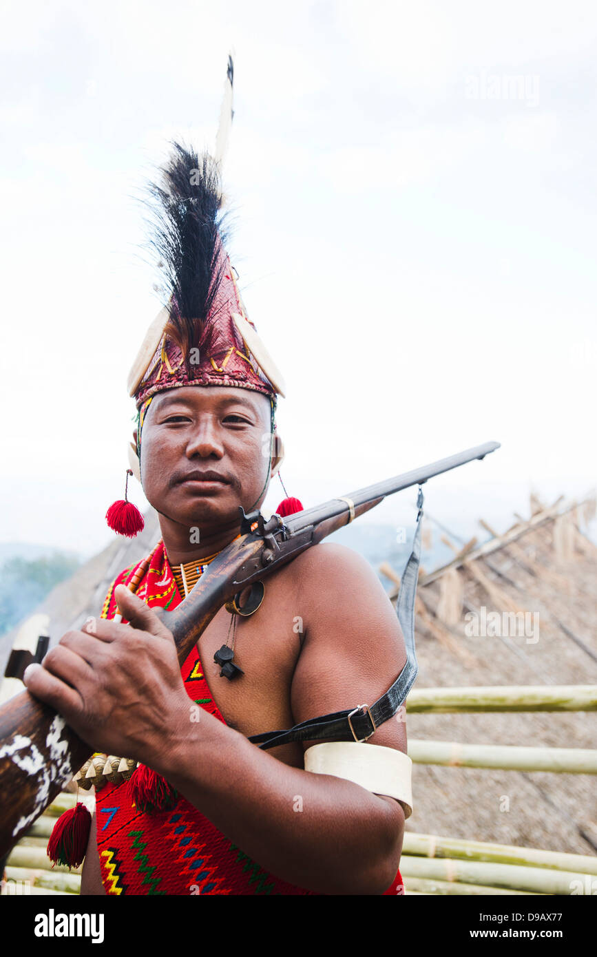 Naga tribal warrior in traditional outfit with a gun, Hornbill Festival ...