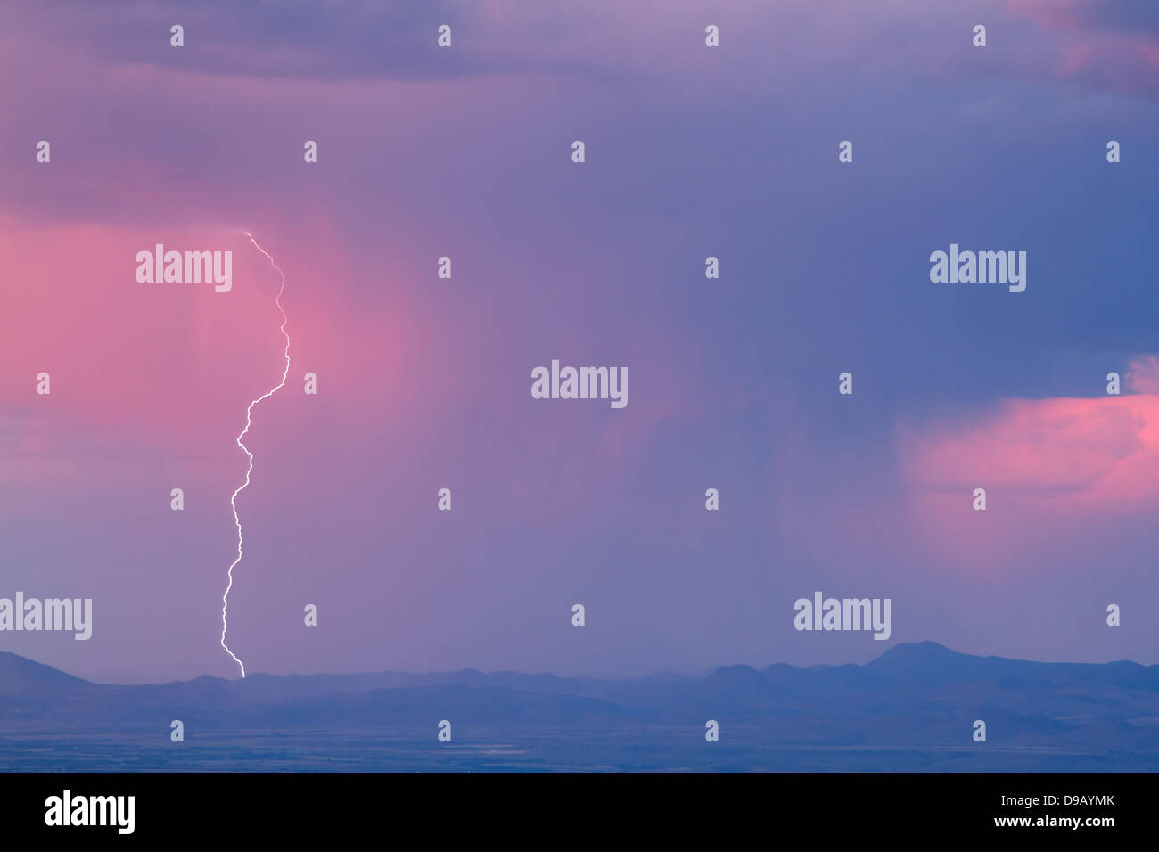 Thunderstorm with lightning and heavy rainclouds at sunset Stock Photo