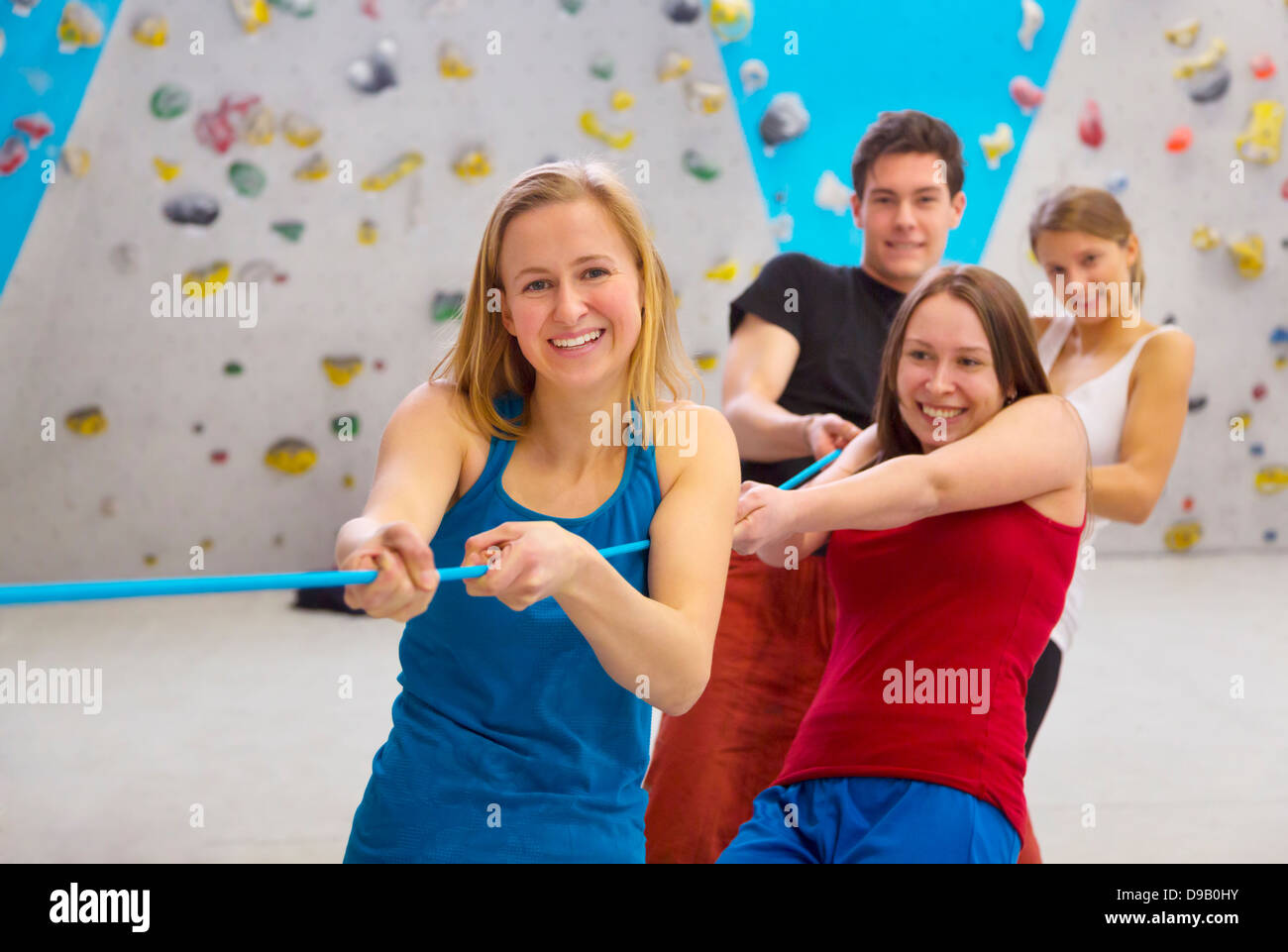 Germany, Bavaria, Munich, Group of friends pulling rope, smiling Stock ...