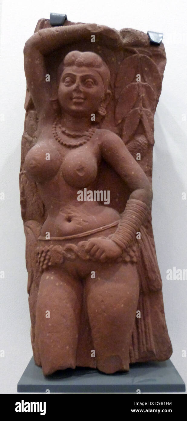 Bracket with Tree Spirits (100-200) Yakshi. Kushan period. In early Indian cults yakshis were female nature spirits. They were then absorbed into Buddhist and Jain worship as images of fertility.  This bracket is carved on each side with a figure of a yakshi holding a flowering part of a gateway marking one of the approaches to a Buddhist or Jain stupa (relic mound). Stock Photo