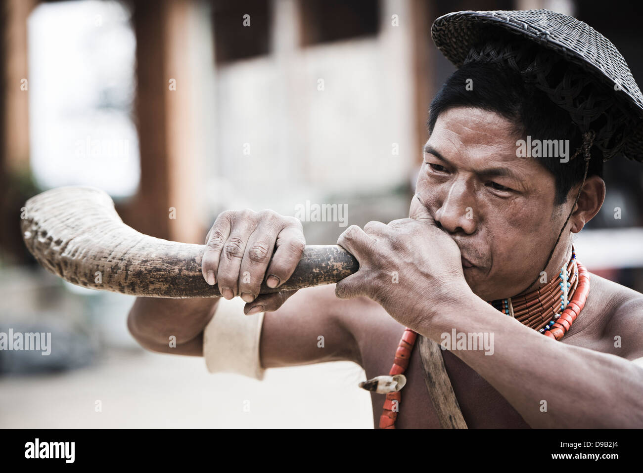 Naga tribesman blowing hunting horn during the annual Hornbill Festival ...