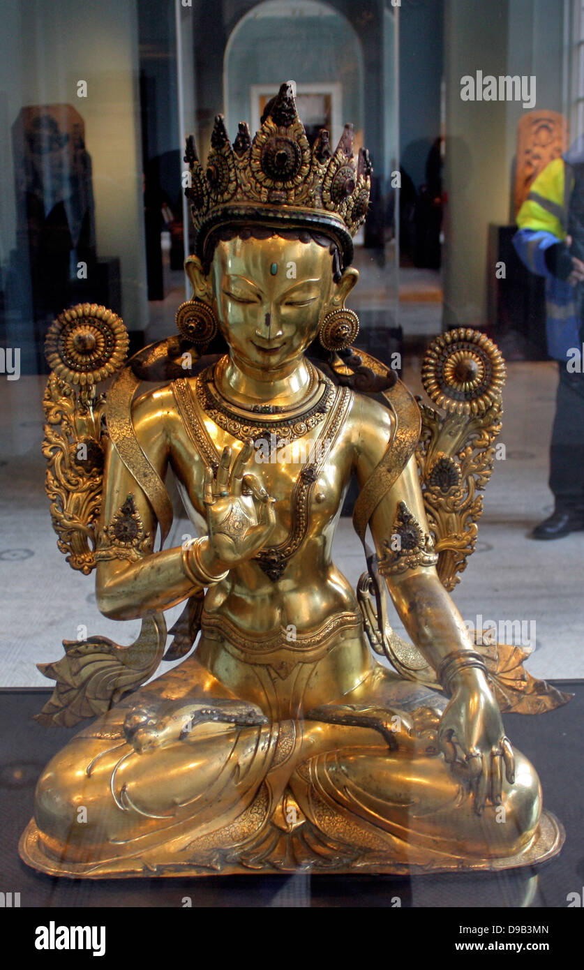 White Tara (1500-1600) Nepal, Gilded copper.  White Tara is one of the most revered, enlightened goddesses in Tibet.  She is shown here with her usual symbols, two open lotus flowers on stalks, one behind each shoulder. Stock Photo