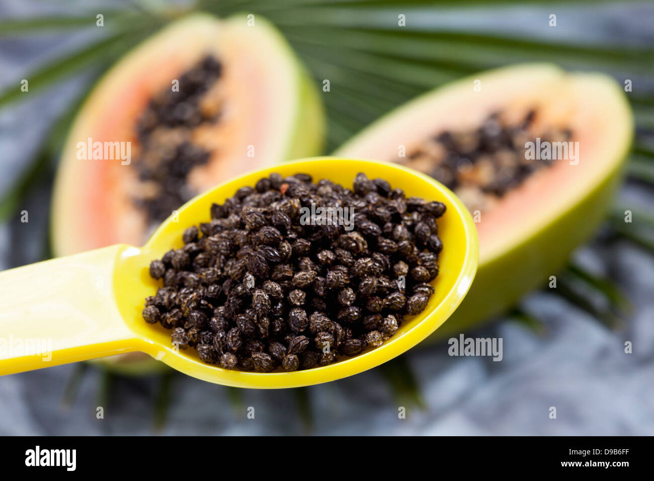 Dried papaya grains on yellow plastic spoon, close up Stock Photo Alamy