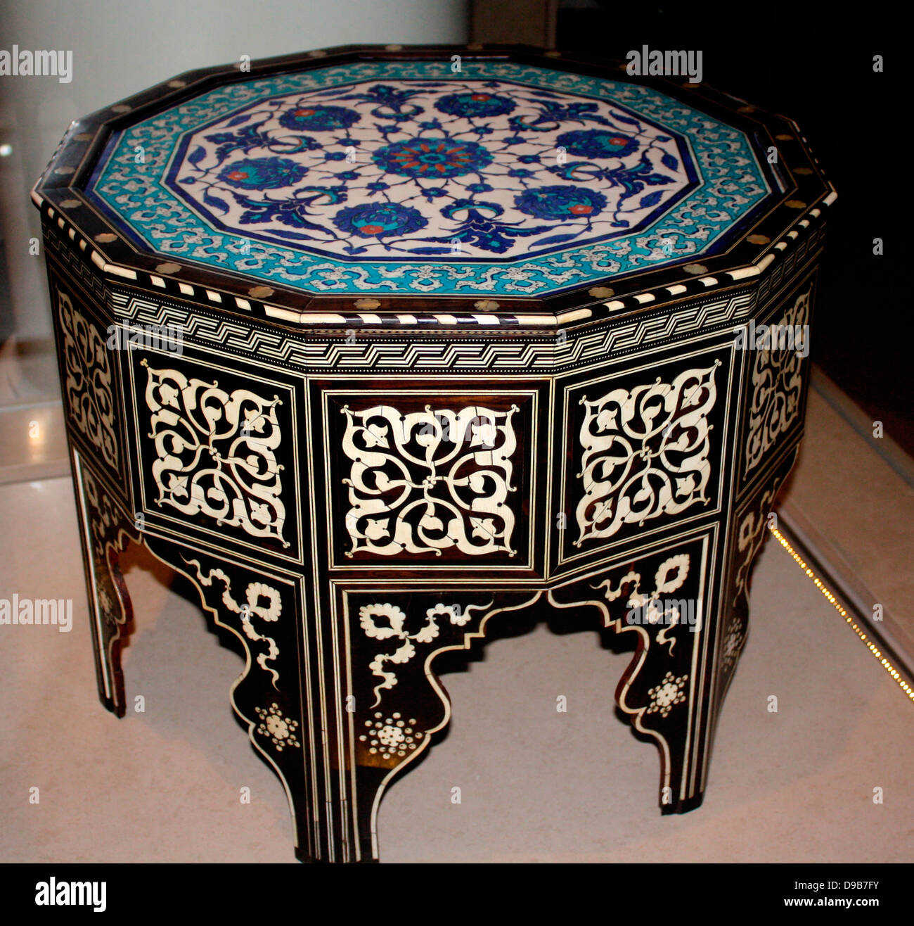 Tile-top Table. Wood faced with ebony, inlay of ivory and mother-of-pearl  fritware painted under glaze. Turkey, Iznik and Istanbul circa 1560. In Ottoman palaces, guests sat on a low bench or divan, built against the wall.  Trays of food and drink were set before them resting on tables of this type. Stock Photo
