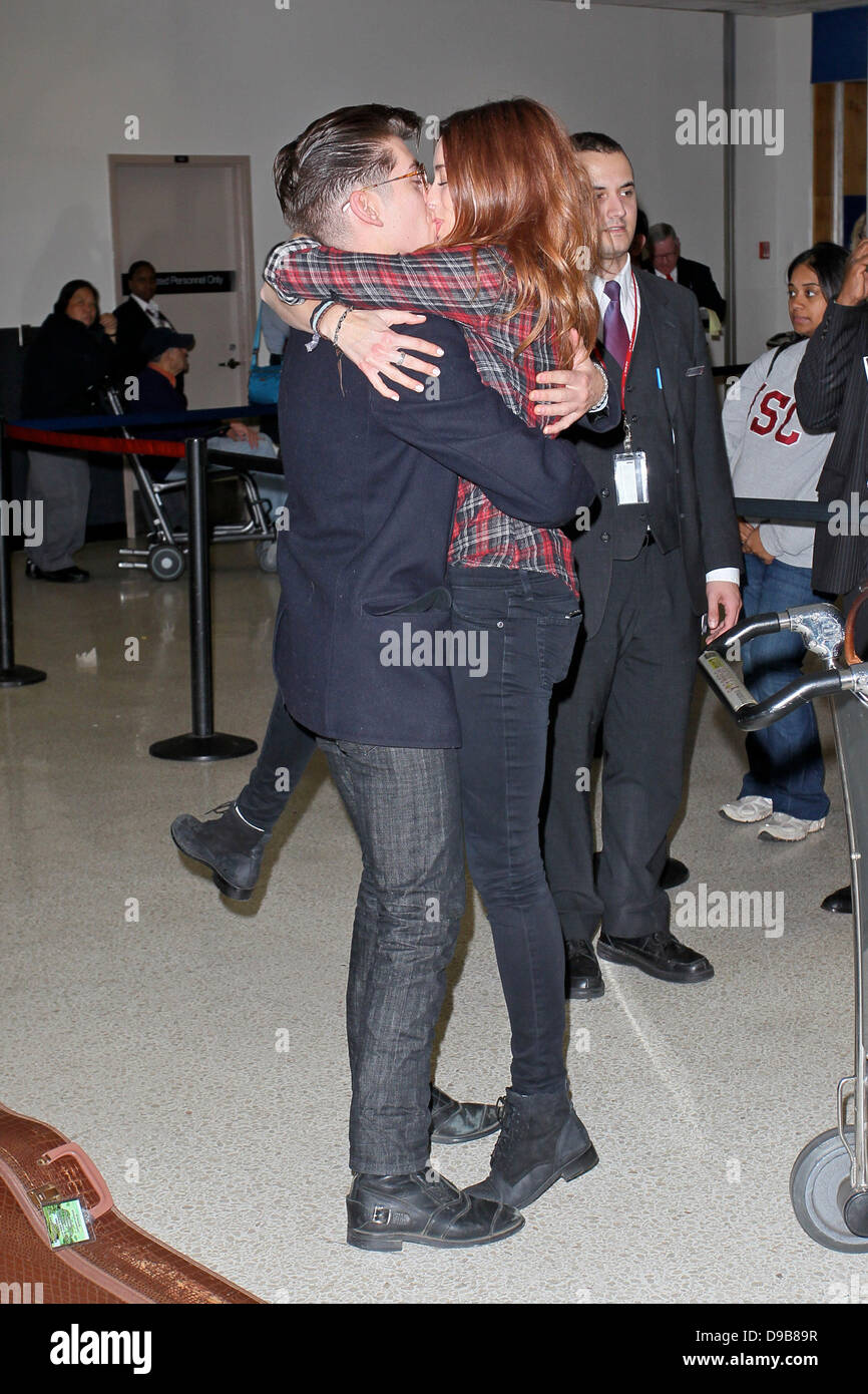 Arctic Monkeys star Alex Turner engages in a very public display of  affection with Arielle Vandenberg as he arrives at LAX Airport. Arielle  planted a big kiss on the rocker after jumping