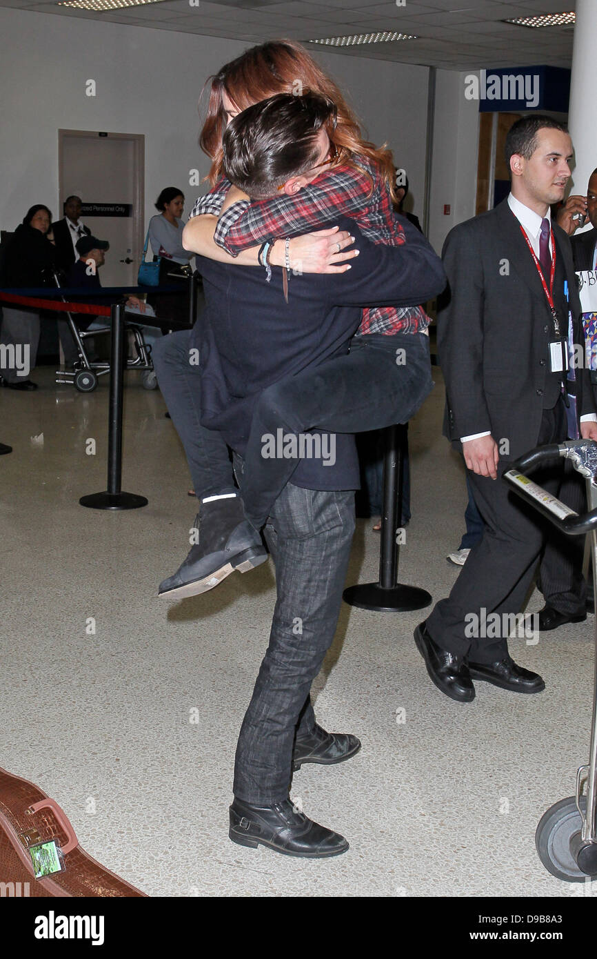 Arctic Monkeys star Alex Turner engages in a very public display of  affection with Arielle Vandenberg as he arrives at LAX Airport. Arielle  planted a big kiss on the rocker after jumping