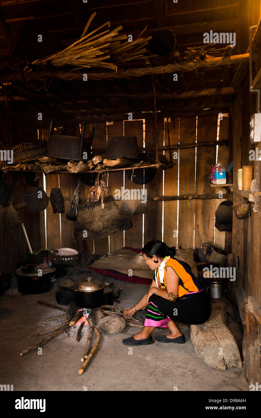 Naga tribeswoman cooking in a hut, Kisama, Kohima, Nagaland, India Stock Photo