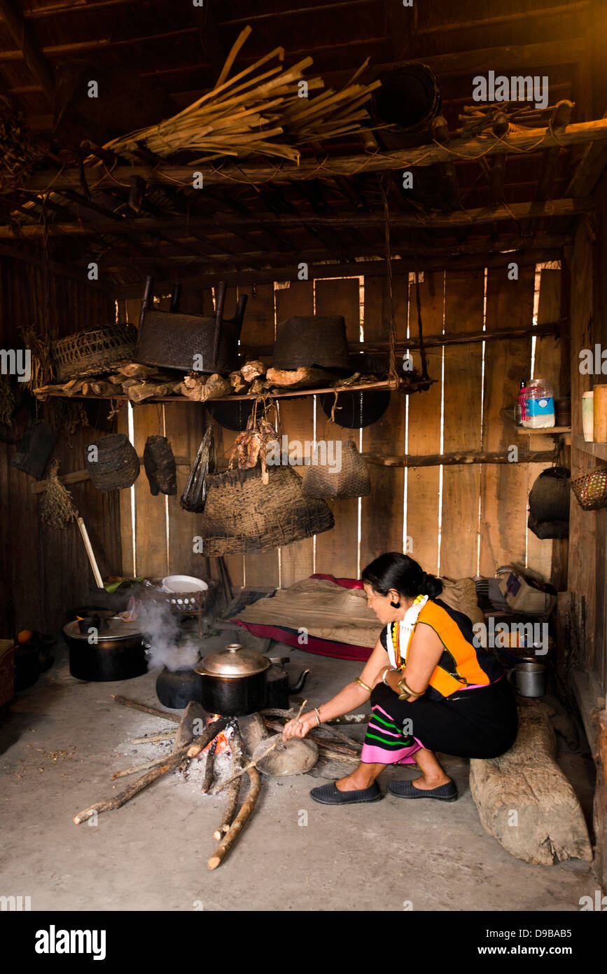 Naga tribeswoman cooking in a hut, Kisama, Kohima, Nagaland, India Stock Photo