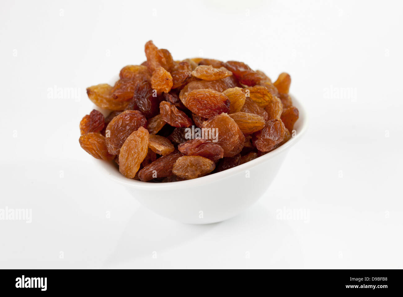 Bowl of sultanas on white background, close up Stock Photo