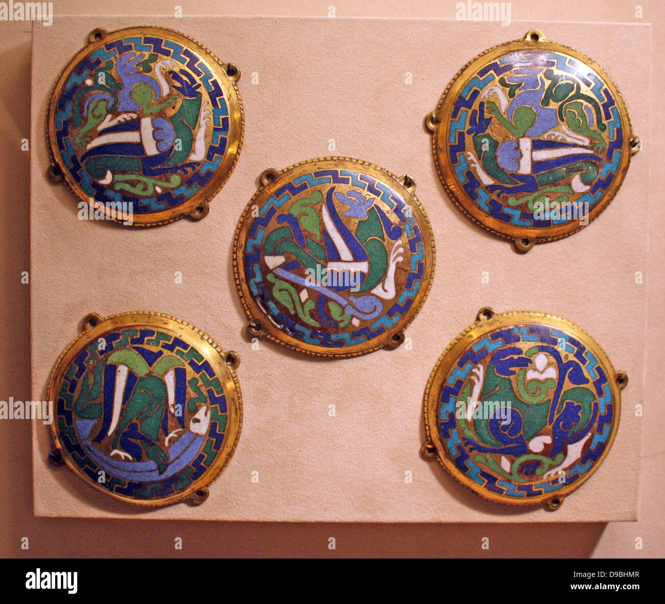 Five Medallions from a Coffret.  Champleve enamel on gilded copper.  French, Conques.  Made about 1110-30  The blue and green beasts, locked in battle and compressed into these circular medallions are emblematic of goldsmiths' work created at Conques under the patronage of Abbot Boniface. Stock Photo