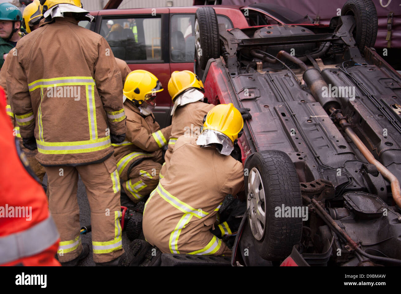 Car Crashed upside down Firemen rescue Driver Stock Photo