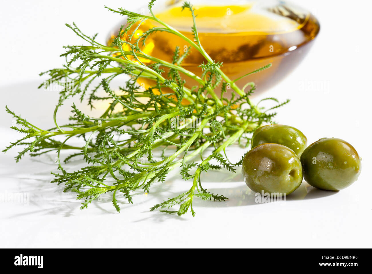Olive herb with olives and olive oil on white background, close up Stock Photo