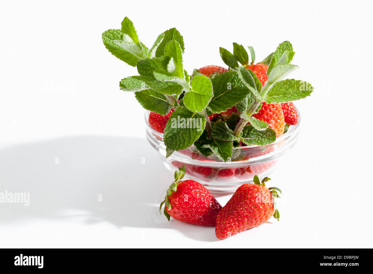Bowl of strawberries with mint on white background, close up Stock ...