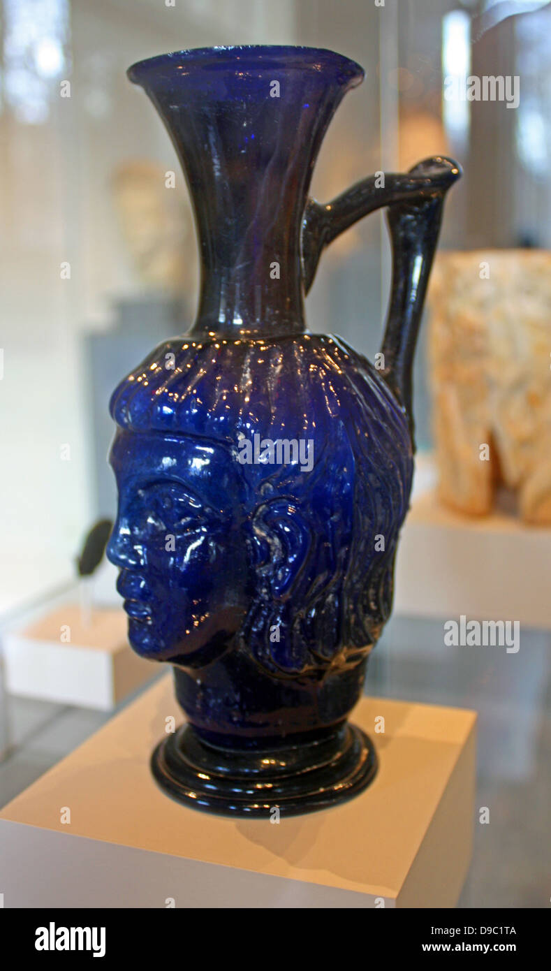 Glass head flask.  Roman, mold-blown, 4th century A.D. The head is that of a youth with large almond eyes and neat, flowing locks that are typical of late Roman portraiture. Stock Photo