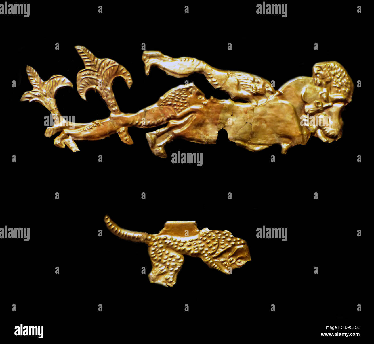 Cut-outs depicting lions attacking a bull among palm trees. Stock Photo