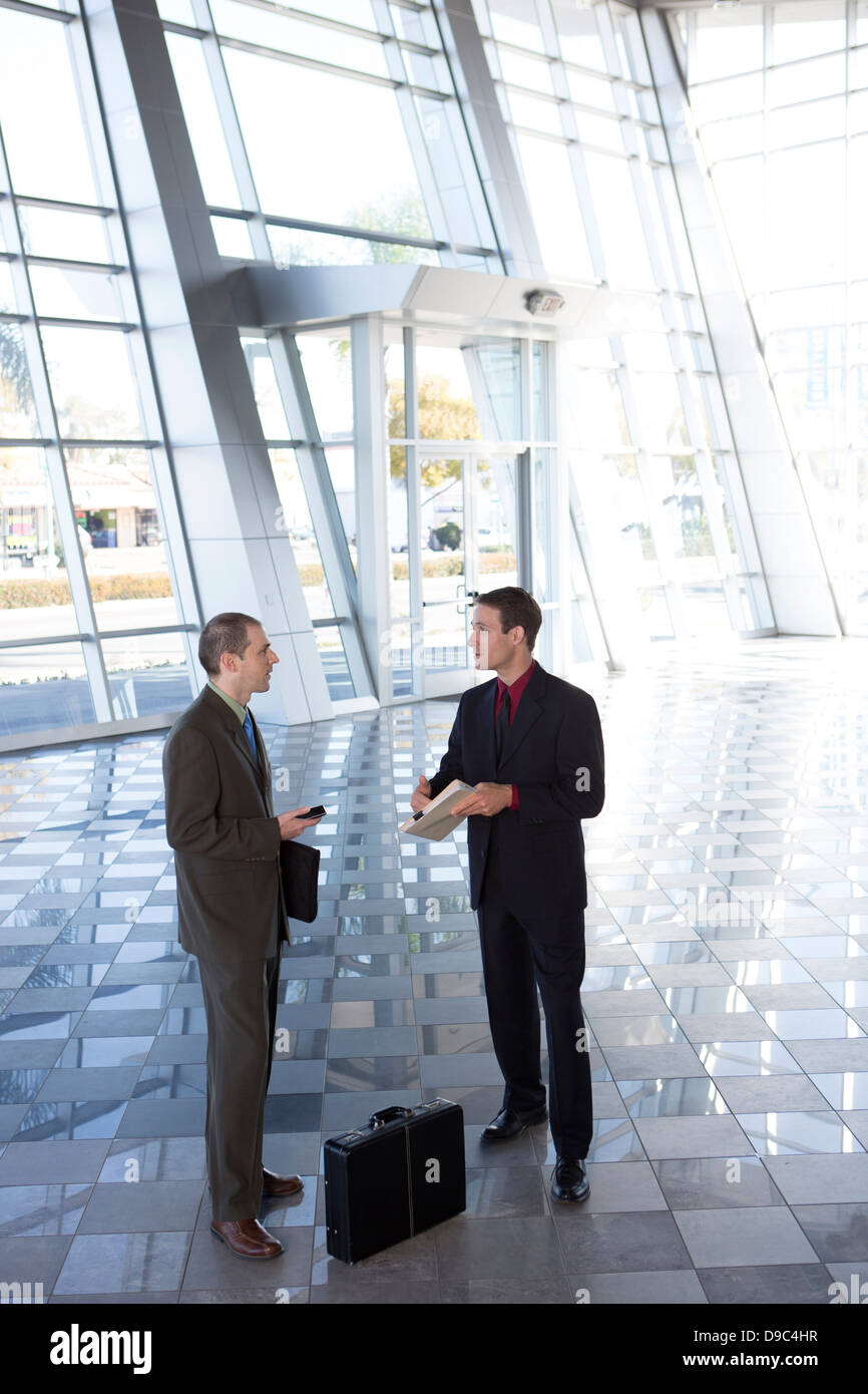 Two businessmen in lobby with briefcase Stock Photo