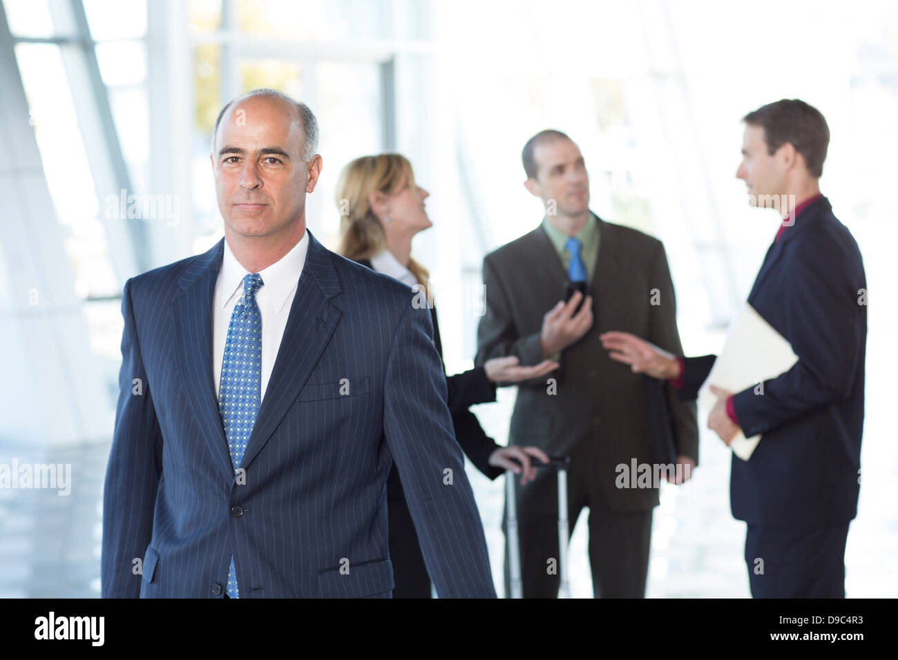 Mature businessman with colleagues in background Stock Photo
